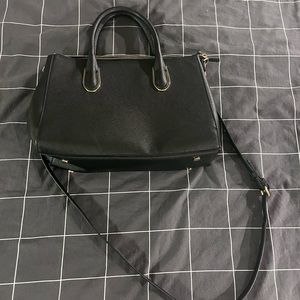 Black purse with handles and crossbody strap
